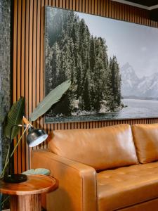 a couch in a room with a picture of trees at The Thompson Hotel in Kamloops