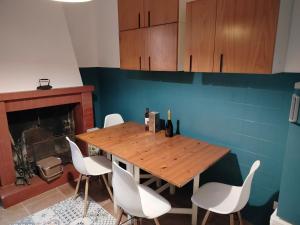 a dining room with a wooden table and white chairs at Casa del Sole 2 artenatura in Pergola