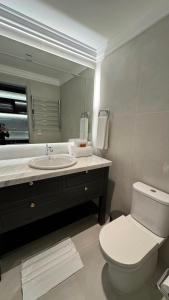 a bathroom with a toilet and a sink with a mirror at Gran Valley Resort in Gramado