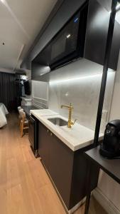 a kitchen with a sink and a microwave at Gran Valley Resort in Gramado