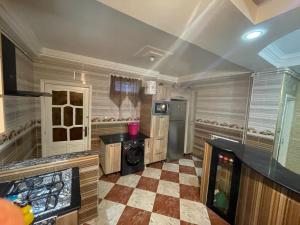 a large kitchen with a checkered floor at Chimino in Sétif