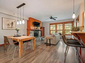 a kitchen and living room with a table and chairs at Tremblant Les Eaux by Rendez-Vous Mont-Tremblant in Mont-Tremblant