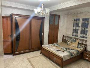 a bedroom with a bed and a wooden cabinet at Chimino in Sétif