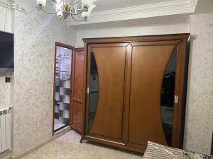 a large wooden closet in a room with a mirror at Chimino in Sétif
