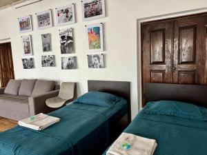 a bedroom with two beds and a couch and pictures on the wall at Khachats Toun Heritage in Meghri +33 photos