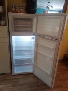 an empty refrigerator with its door open in a kitchen at Chalupa U Tety v Bystrém in Dobruška