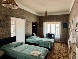 a bedroom with two beds and a desk in it at Khachats Toun Heritage in Meghri