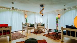 a living room with white drapes and couches at Villa Amani in Malindi