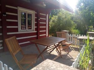 a picnic table and two chairs outside of a cabin at Chalupa U Tety v Bystrém in Dobruška