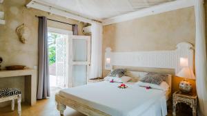 a bedroom with a white bed and a window at Villa Amani in Malindi