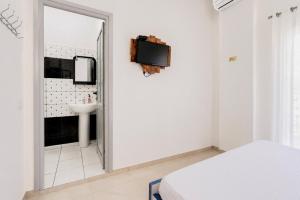 a white bedroom with a bed and a sink at South Hotel Berat in Uznovë