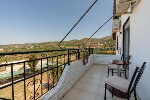 a balcony with two chairs and a table with a view at South Hotel Berat in Uznovë