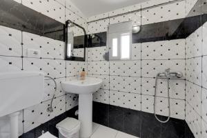 a bathroom with black and white tiled walls and a sink at South Hotel Berat in Uznovë +52 photos