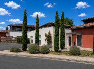 a house with a row of cypress trees at Résidence Les Alizés Bordeaux Sud - La Brède in La Brede