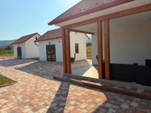 a house with a pavilion on a brick patio at Mély-Patak Vendégház in Erdőbénye