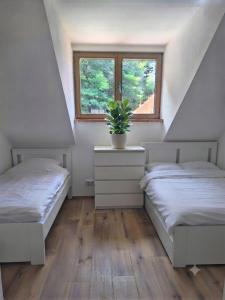 two beds in a room with a window at Central Starnberg and surrounded by nature in Starnberg