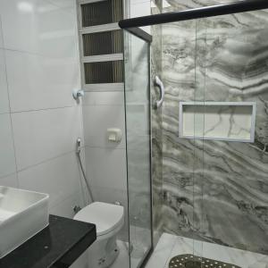 a bathroom with a shower with a toilet and a sink at Castanheiras,perto de tudo,Internet,cadeiras,cooler e guarda sol in Guarapari +23 photos