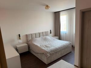 a white bedroom with a bed and a window at Mély-Patak Vendégház in Erdőbénye