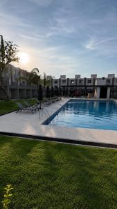 a large swimming pool with chairs and a building at Casa completa de fin de semana Cuautla in Tlayecac