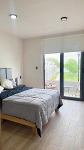 a bedroom with a large bed and a large window at Casa completa de fin de semana Cuautla in Tlayecac