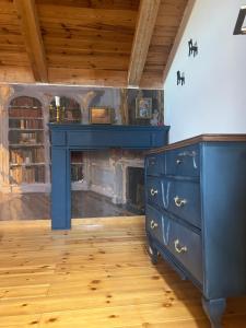 a blue dresser in a room with a fireplace at La Alcoba de los Cuentos in Urueña