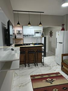 a kitchen with a white refrigerator and a sink at Castanheiras,perto de tudo,Internet,cadeiras,cooler e guarda sol in Guarapari