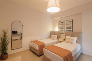 a small room with two beds and a mirror at Villa Agrielia in Póndi +30 photos