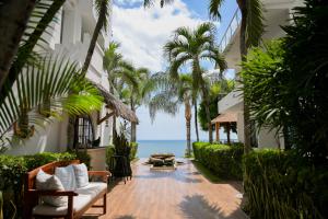 an outdoor patio with palm trees and the ocean at Hotel Vistalmar in Manta