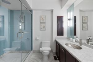 a bathroom with a toilet and a glass shower at Stylish 4BR Toronto House Backyard Dinners in Toronto