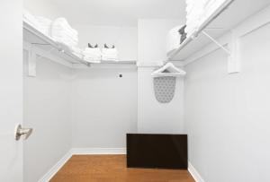 a living room with white walls and a tv and shoes at Stylish 4BR Toronto House Backyard Dinners in Toronto +31 photos