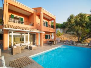 a villa with a swimming pool in front of a house at Villa Agrielia in Póndi