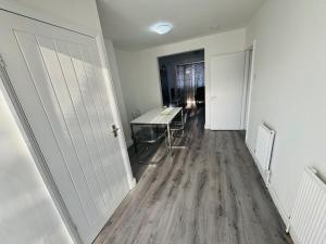 a room with a hallway with a desk and a table at Romford 4-Bed Home Sleeps 7 with Garden & Parking in Romford +18 photos