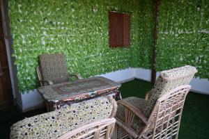 two chairs and a table in a room with green wall at شقة رويال سويت in Abu Simbel