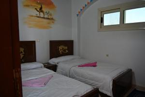 a room with three beds and a window at شقة رويال سويت in Abu Simbel