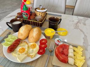 a plate of breakfast food with eggs sausage bread and fruit at HagiangTrips Hotel in Ha Giang +16 photos