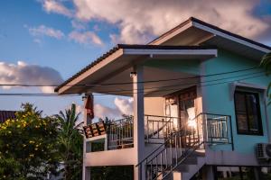 a blue and white house with a balcony at Modern Nature Retreat in Ko Phangan