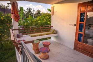 a porch with a bench and three vases on it at Modern Nature Retreat in Ko Phangan