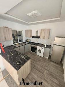 a large kitchen with a stove and a dishwasher at Sablette mostaganem in Les Sablettes Mazagran-Plage