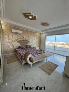 a bedroom with a large bed with a large window at Sablette mostaganem in Les Sablettes Mazagran-Plage