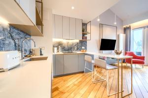 a kitchen with white cabinets and a table and chairs at Lake Rental Inpro 89 in Mikołajki