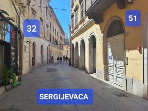 an empty street in a city with signs on buildings at Dejan apartment4-Top centar in Pula