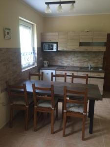 kuchnia z drewnianym stołem i drewnianymi krzesłami w obiekcie Kislőd Apartman w mieście Kislőd