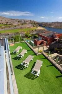 a group of chairs and chairs on a yard with grass at Villa Los Dragos Golf by Infinity Summer in San Bartolomé