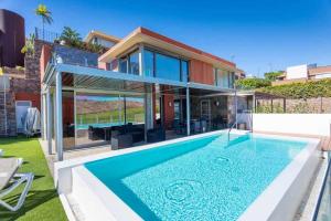 a house with a swimming pool in front of a house at Villa Los Dragos Golf by Infinity Summer in San Bartolomé
