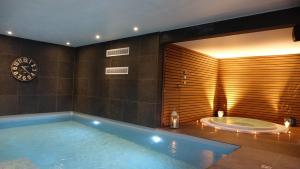 a bathroom with a tub and a clock on the wall at Hôtel Panorama - Vue exceptionnelle sur la Semois in Bouillon