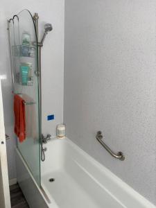 a bathroom with a bath tub with a glass shower at Sunny and Comfortable Studio in Southport