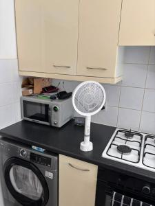 a kitchen with a microwave and a fan on a counter at Sunny and Comfortable Studio in Southport