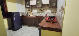 a kitchen with a red stove and a refrigerator at Carmel Stay in Madurai