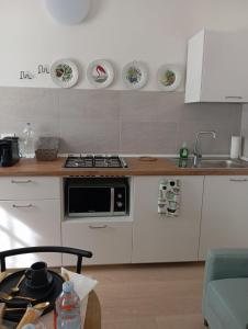 a kitchen with white cabinets and a sink and a stove at CasaMirandola in Vicenza