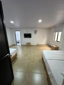 a bedroom with two beds and a flat screen tv at Hotel Central Park Cartago in Cartago